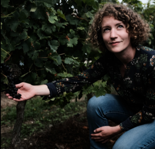 Winemaker Pauline in vineyard holding grapes