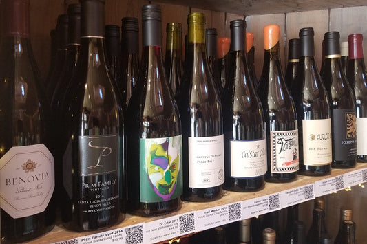 Shelf of assorted wine bottles, including several Pinot Noir labels.