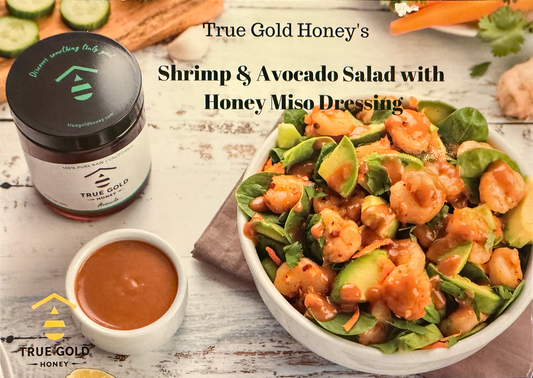 Shrimp and avocado salad with honey miso dressing, with honey jar and dressing cup nearby