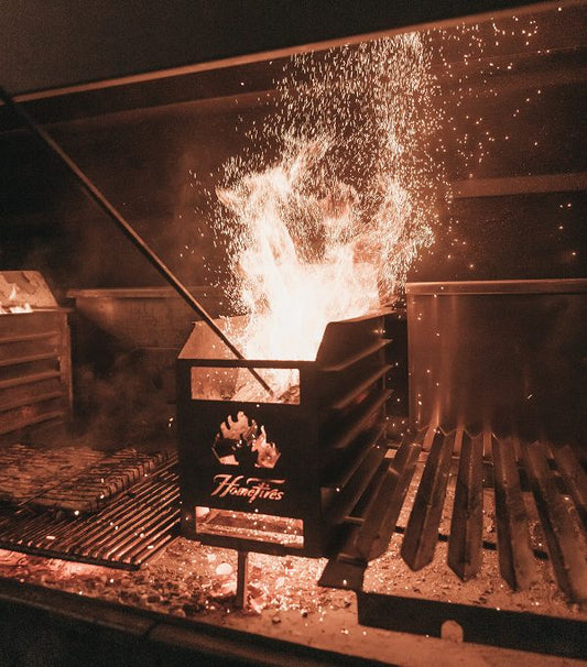 Flames and sparks from a barbecue grill in a dark cooking area