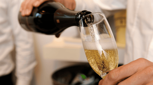 Sparkling Italian wine being poured into a champagne flute during a wine tasting at Farmstead Cheeses & Wines.
