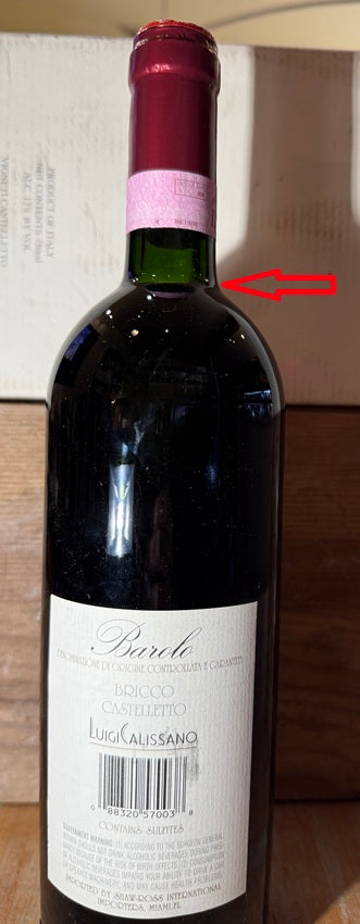 Back side of a Bottle of 1993 Barolo from Luigi Calissano with red arrow showing fill level at top of shoulder