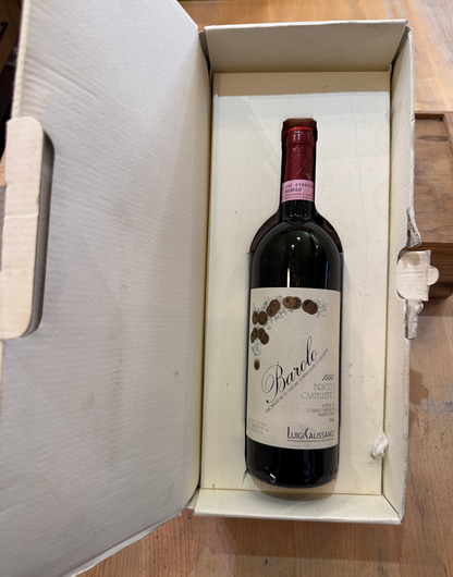 Red wine bottle in its original white box on a wooden surface - 1993 Barolo, Luigi Calissano