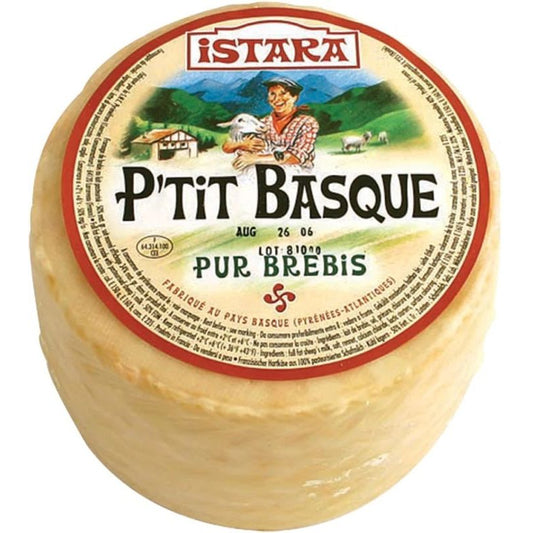 A round cheese wheel with packaging that includes the brand name 'Istara' and the product name 'P'tit Basque' with a picture of a sheep and a scenic background.