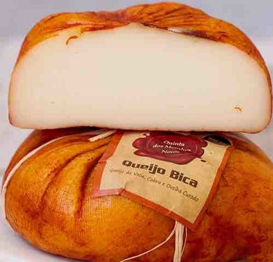 Bica de Queijo on a white background. An orange-rind cheese with a colorful exterior and a smooth paste of the interior.