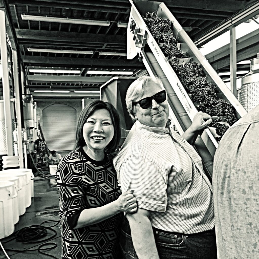 Winery owners Donald Patz and his wife Jung Min standing together in the winery during processing of the harvest.