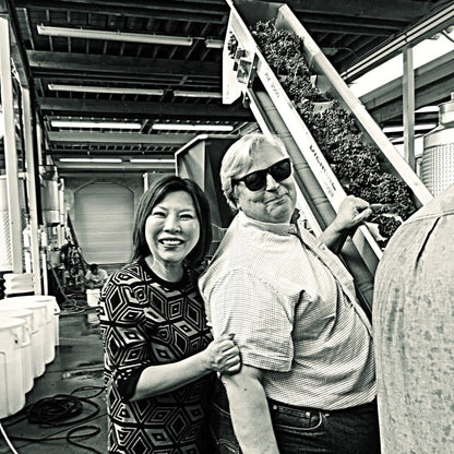 Winery owners Donald Patz and his wife Jung Min standing together in the winery during processing of the harvest.