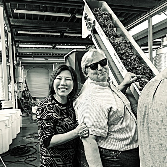 Winery owners Donald Patz and his wife Jung Min standing together in the winery during processing of the harvest.
