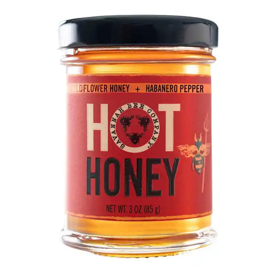 A 3 oz glass jar of Savachee Bee Colony 'Hot' Honey with habanero pepper, featuring a red label and black lid on a white background.