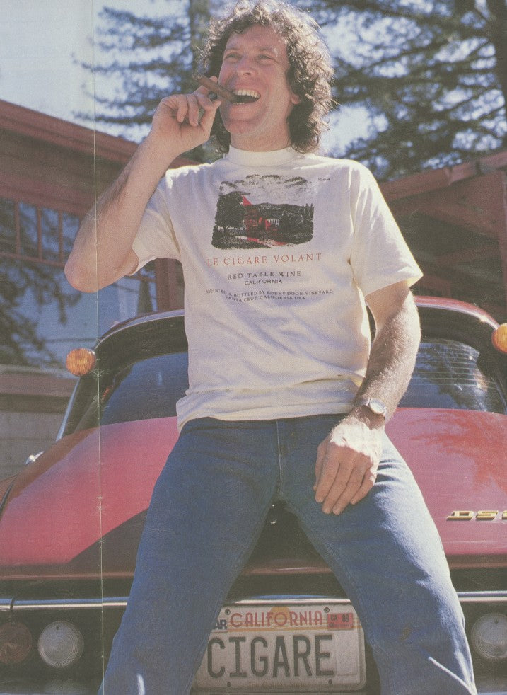 1980s photo of Winemaker Rangall Grahm sitting on the back of his Citroen with 'Cigare' on the license plate.